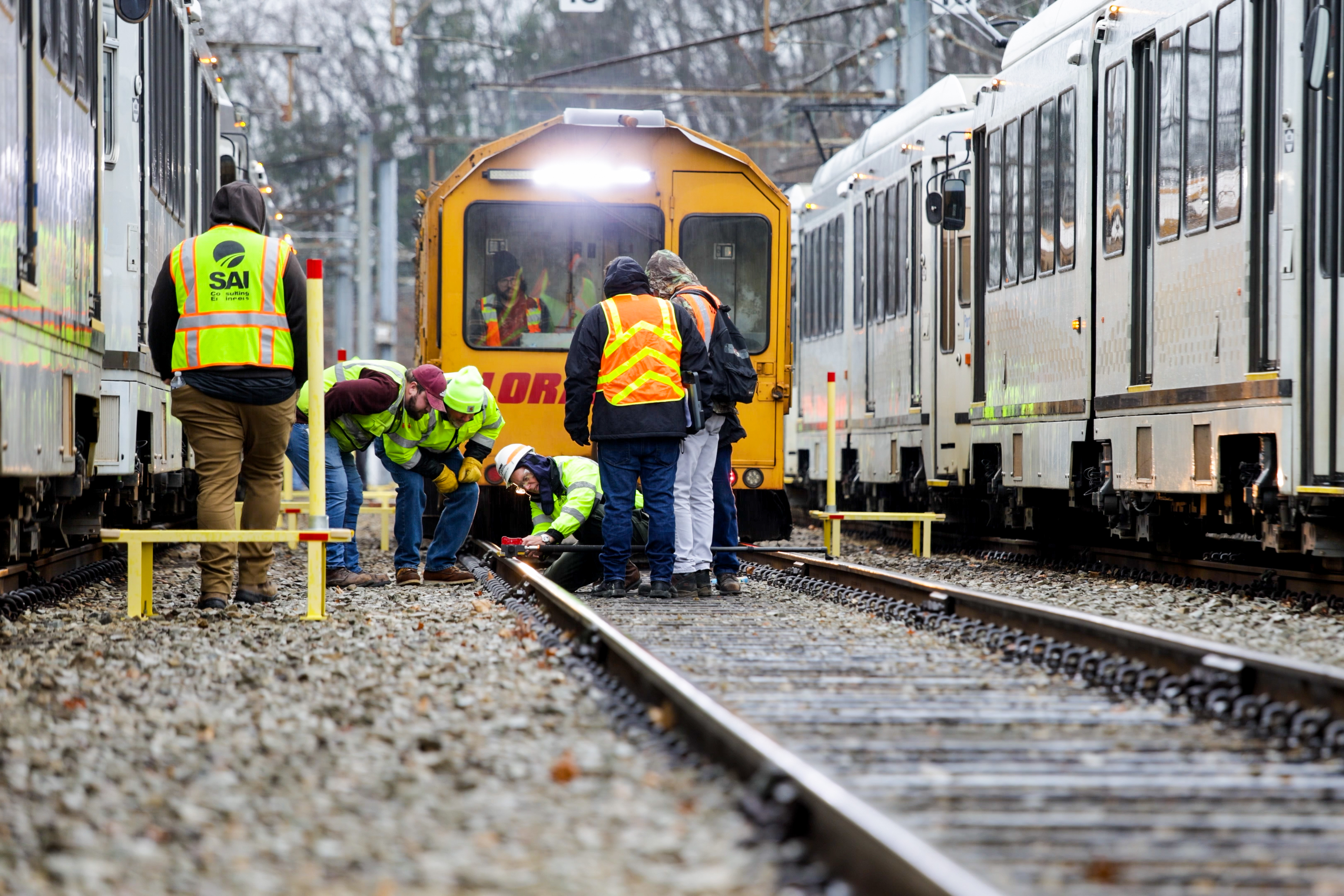 Workers performing maintenance on a light rail car